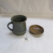 A very small St. Ives pottery plate and a pottery mug by M. Schloessingk