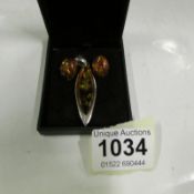 A silver and amber pendant and earring set