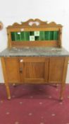 A marble topped washstand with tiled back