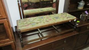 A long footstool with tapestry top