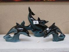 A large Poole pottery dolphin group and a pair of Poole dolphins