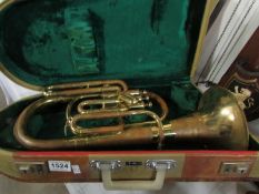 A cased brass horn by Lark