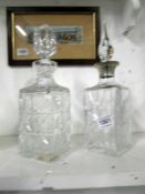 A glass decanter with silver collar and one other