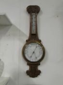 A carved oak barometer