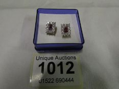 A pair of 14ct earrings set 1ct diamonds and rubies