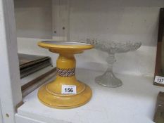 A glass cake stand and a ceramic stand