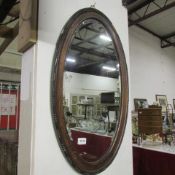 An oak framed oval bevel edged mirror