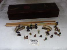 A lacquered glove box containing Oriental figures and chopsticks