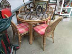 A bamboo table with glass top and 4 chairs