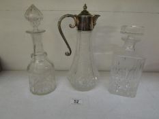 A claret jug and 2 decanters