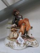 A Capo Di Monte figure of a tramp on a bench