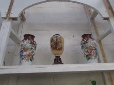 A pair of hand painted vases and one other hand painted vase