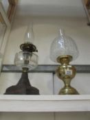 A brass oil lamp with shade and an oil lamp with glass font
