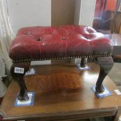 A deep buttoned leather footstool