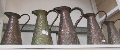 A set of 5 graduated copper jugs