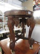 A carved wood circular table with ivory