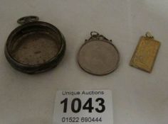 A silver pocket watch case, a pendant and a coin pendant