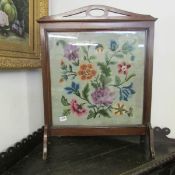 A mahogany fire screen with embroidered inset