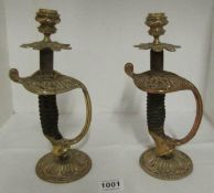 A pair of brass candlesticks made from sword hilts (26cm)