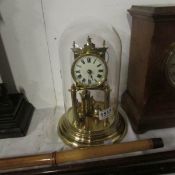 A brass anniversay clock under glass dome