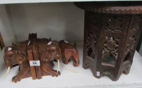 A pair of elephant bookends and carved table