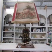 A table lamp surmounted horse and with hunting print shade