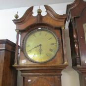 An oak long case clock with brass face