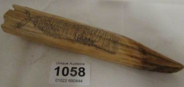 A Scrimshaw walrus tusk carved with a whale and dated 1790