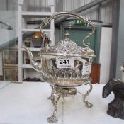 A silver plate tea pot with burner