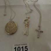 A Silver locket, silver key and silver cross all on silver chains