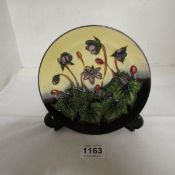 A Moorcroft plate with purple flowers