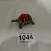 A cold painted lead tortoise pin cushion