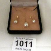 A pearl pendant on 9ct gold chain and matching earrings