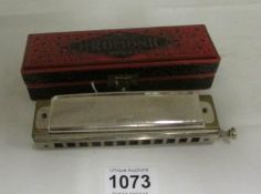 A cased Chromonica by Hohner