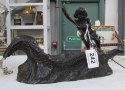 A bronze figure of boy in 'Dugout' boat