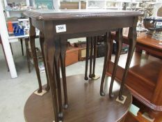 A nest of 3 tables with leather insert and glass tops