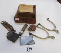 A money box containing military lighter, spurs etc