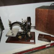 An early sewing machine in wood case