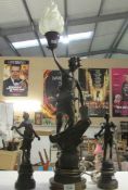 A spelter figure lamp and a pair of spelter figures