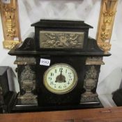 A black marble mantle clock with brass decoration