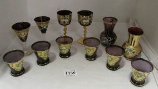 A quantity of amethyst coloured glassware with gilt decorations including 6 shot glasses