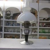 An Alladin oil lamp with white glass shade