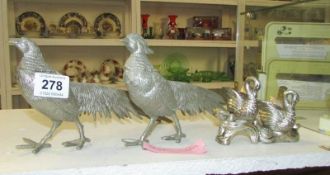 A pair of silver plated fighting cocks and 2 swans