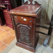A mahogany pot cupboard with carved door