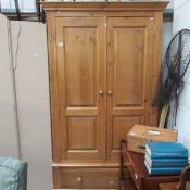 A pine wardrobe with bottom drawer