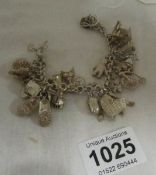 A silver charm bracelet with English and Continental charms, approx. 70gms