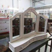 A freestanding dressing table mirror with drawers