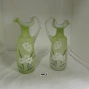 A pair of Victorian hand painted green glass ewers with twist handles, 25cm tall