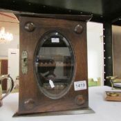 An oak smoker's cabinet with bevelled glass door