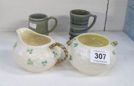 A Belleek milk jug and sugar bowl and 2 Irish pottery cups